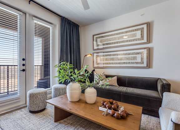 A living room with a couch, a coffee table, and a plant.