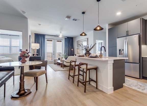 A modern kitchen with a bar area and a dining table.