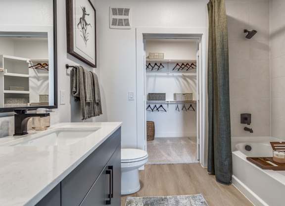 A bathroom with a white tub and a white toilet.