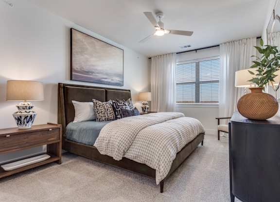 A bedroom with a large bed and a ceiling fan.
