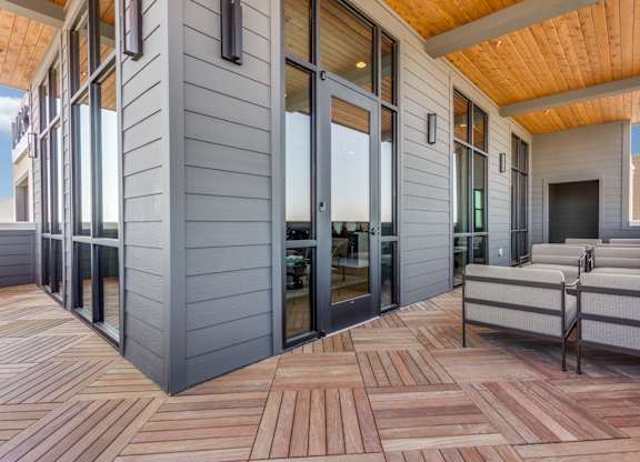A modern house with a wooden deck and sliding glass doors.