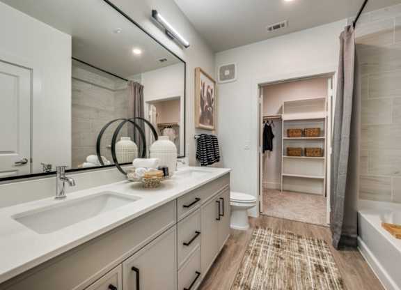 A bathroom with a sink, mirror, and a toilet.