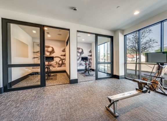 A room with a bench and a television with a view of the outdoors.