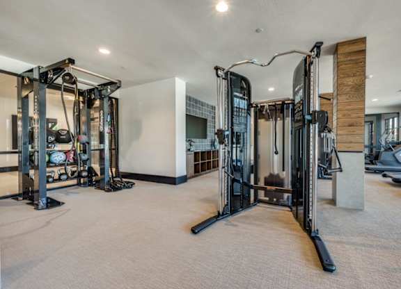 A spacious gym with a variety of equipment including treadmills, stationary bikes, and weight machines.
