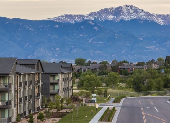 an aerial view of apartment buildings with mountains in the background