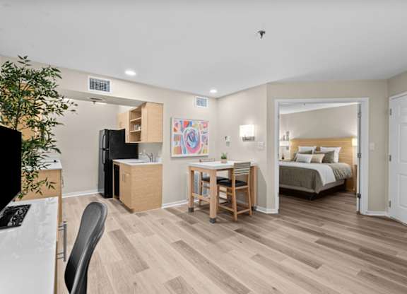 A room with a bed, a desk, and a chair.