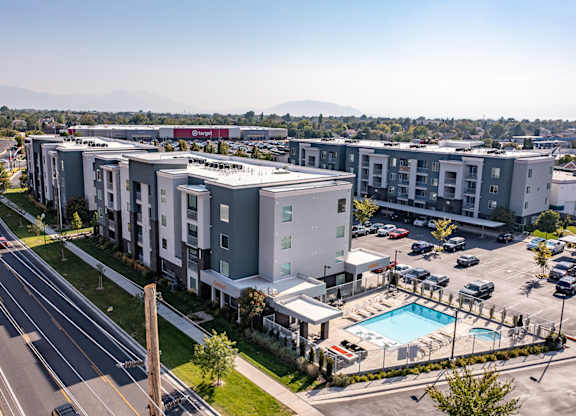 A large apartment complex with a pool and a parking lot.