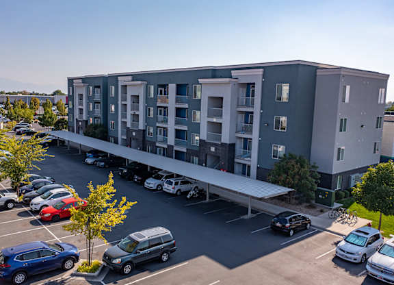 A parking lot with cars and a building in the background.