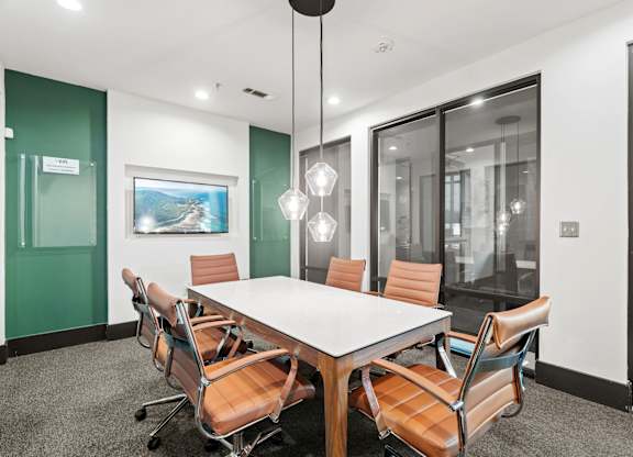 A conference room with a long table and chairs.