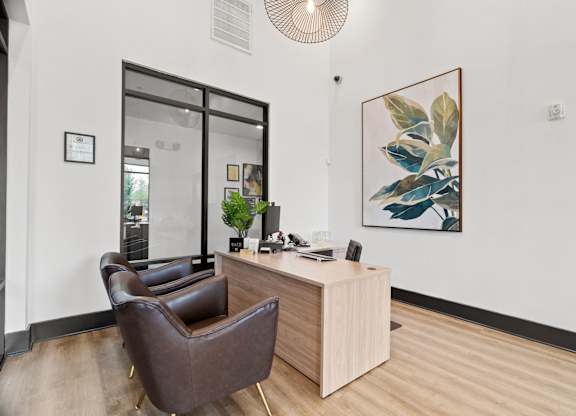 A brown leather chair sits in front of a wooden desk with a plant on it.