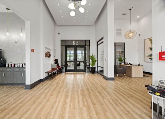A modern office lobby with a wooden floor and white walls.