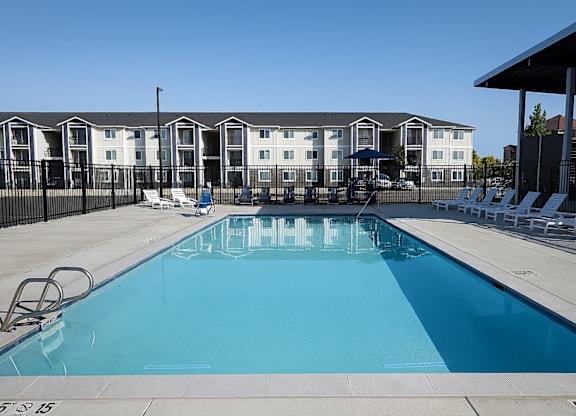A swimming pool in front of apartment buildings.