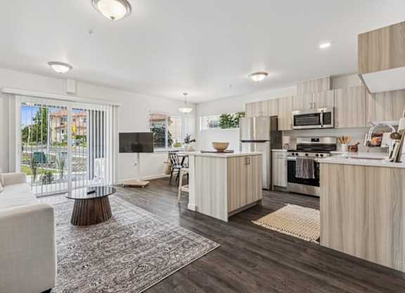 A modern kitchen with a white sofa and wooden cabinets.