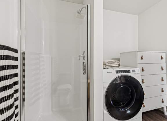 A black and white striped towel hangs on a glass door.