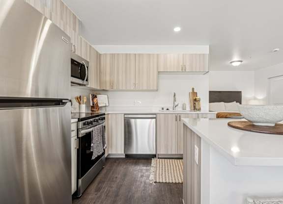 A modern kitchen with a stainless steel refrigerator and a white countertop.