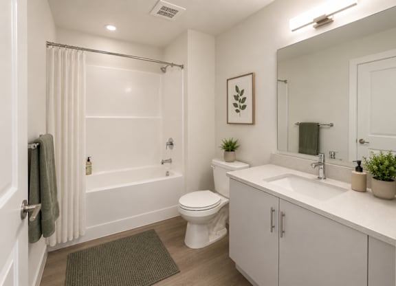 A white bathroom with a toilet, sink, and shower.
