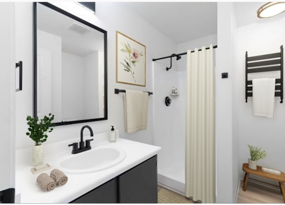 Bathroom with white countertops, white walls, and black cabinets at The Rosewood Apartments in Vancouver, Washington.