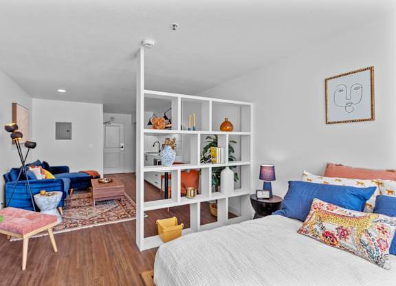 a bedroom with a bed and a living room with a couch and a chair