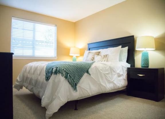 a bedroom with a bed and two lamps