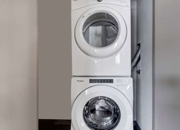Two white washing machines stacked on top of each other.