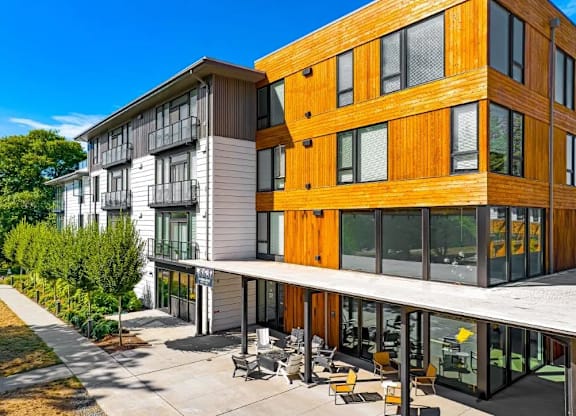 A modern building with a wooden facade and a glass balcony.