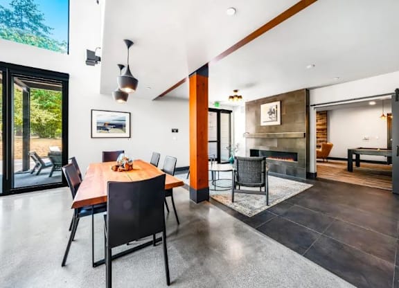 A modern dining room with a wooden table and chairs.