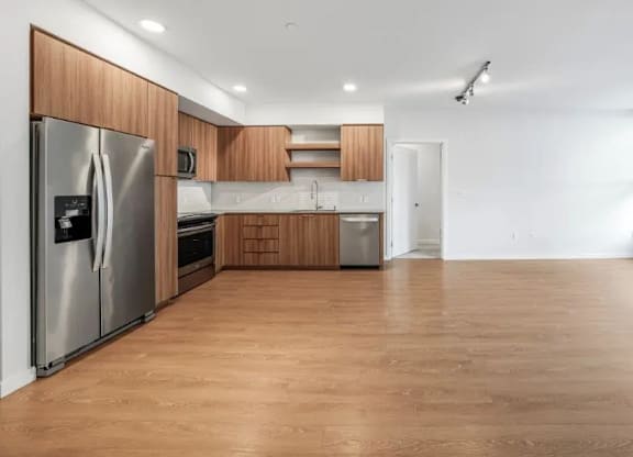 A kitchen with wooden floors and stainless steel appliances.