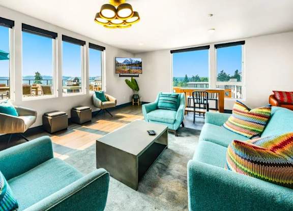 A living room with a large window overlooking the beach.