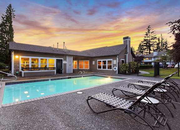 A house with a pool in front of it.