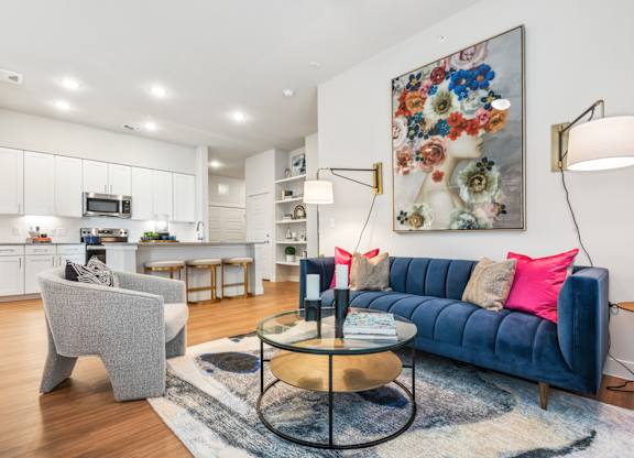 A living room with a blue couch and a grey armchair.