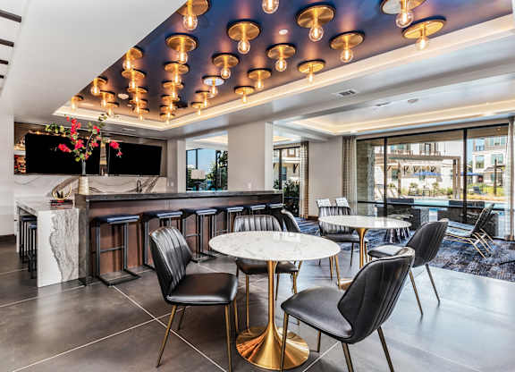 A modern bar with black chairs and a white counter.