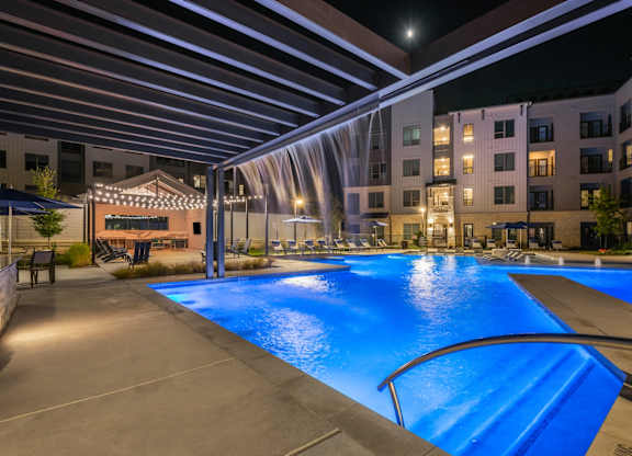 A large outdoor swimming pool with a slide at a resort.
