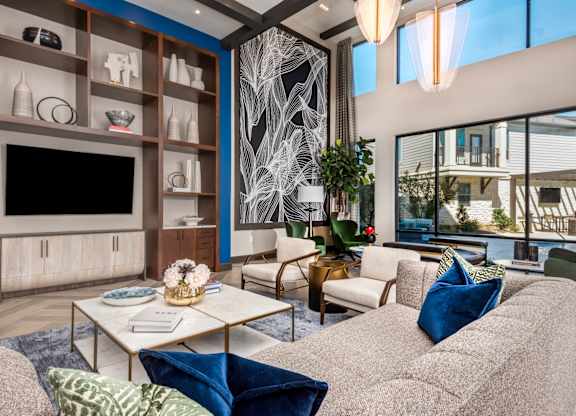 A living room with a grey couch, a coffee table, and a TV.