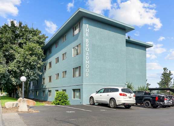 The Broadmoor building has a parking lot in front of it.