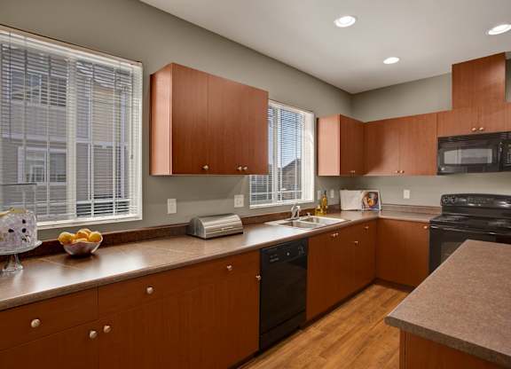 A kitchen with wooden cabinets and a black oven.