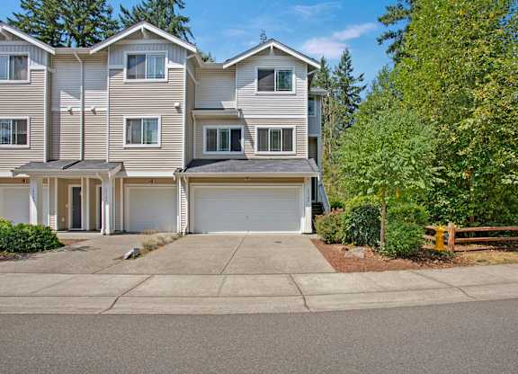 A large, multi-story residential building with a driveway in front.