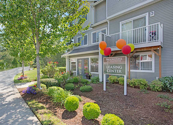 A leasing center for Brookstone is shown with a well kept garden.