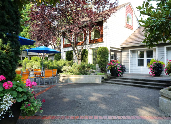 Fulton's Crossing and Landing Apartments  patio and yard of a white house with a patio table and chairs