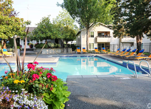 Fulton's Crossing and Landing Apartments  swimming pool with chairs and flowers around it
