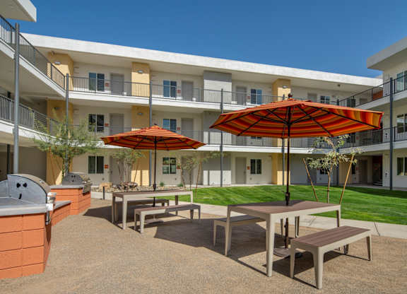 A patio with a table and chairs and an umbrella.