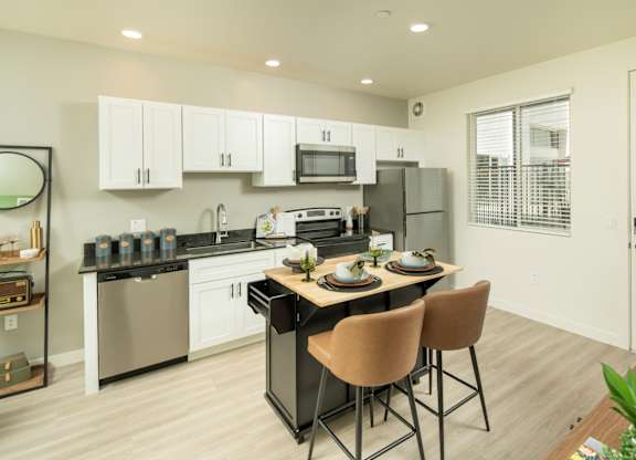A modern kitchen with a dining table set for two.