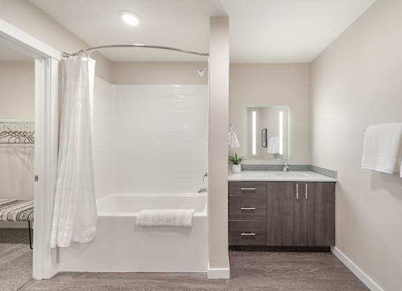 A bathroom with a white tub and sink.