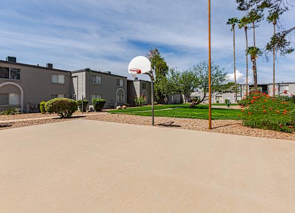 A basketball hoop stands in the middle of a driveway.