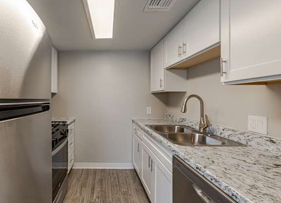 A kitchen with a sink and a refrigerator.