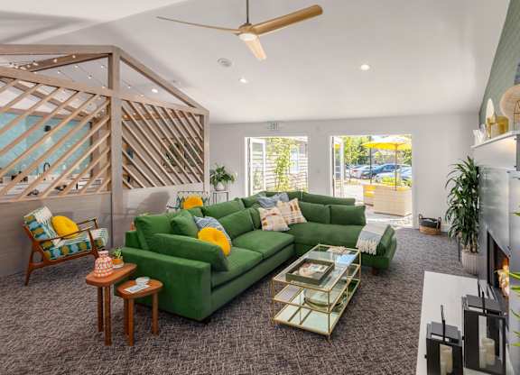 A living room with a green couch and a wooden chair.
