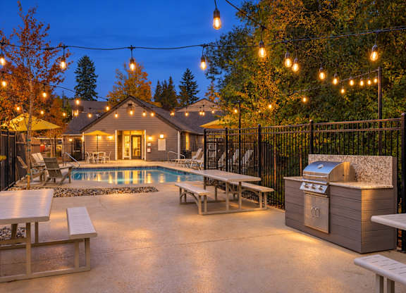 A backyard with a pool and picnic tables.