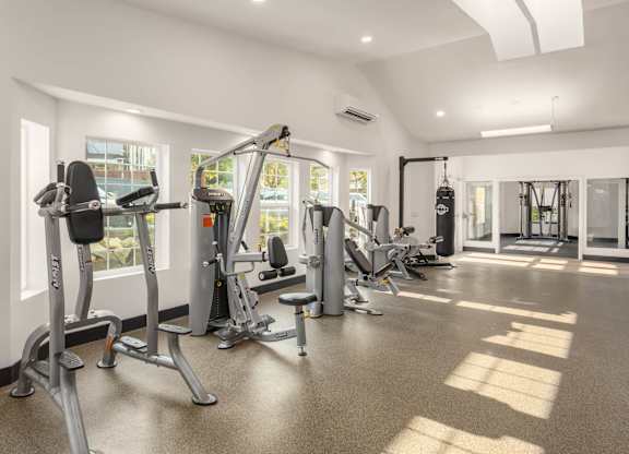 A spacious gym with a variety of equipment including treadmills, stationary bikes, and weight machines.