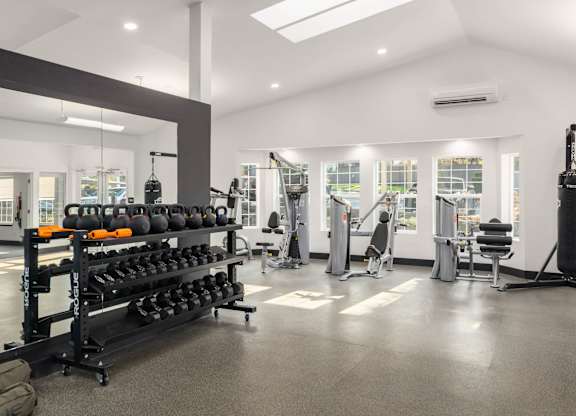 A gym with a variety of equipment including weights and machines.