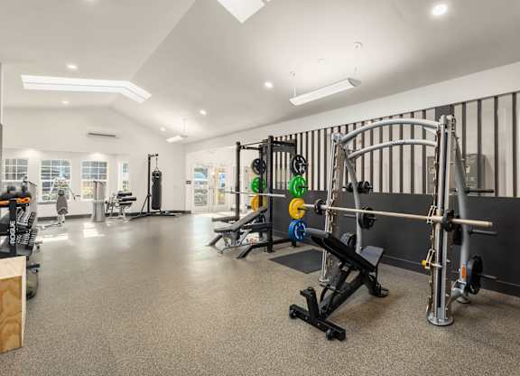 A gym with a variety of equipment including weights and machines.