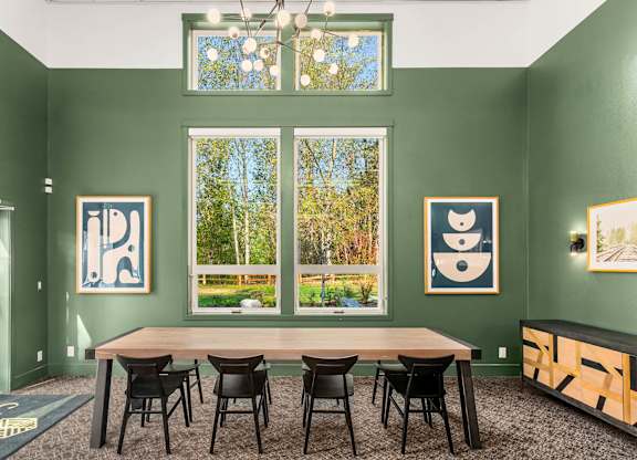 A room with green walls and a table with chairs.